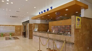 A hotel reception area with a marble floor, a reception desk, a counter with a computer, and a wall with a sign that reads 'FRONT'. - Toyoko Inn Mito Eki Minami Guchi (Mito)