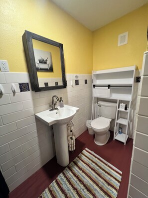 Une salle de bain avec un lavabo, des toilettes et un miroir.