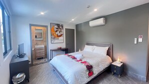 A modern bedroom with a large bed, bedside tables, a desk, and a trash bin. - Private studio near street (Padstow)