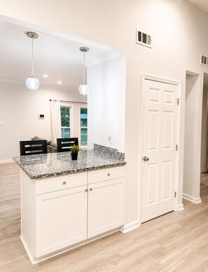 A kitchen with white cabinetry, a granite countertop, and pendant lighting. - 2-bedroom house in peaceful East Point Atlanta (East Point)