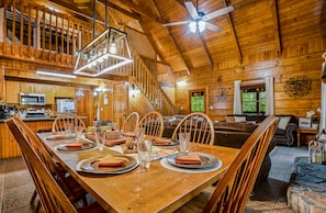 Ein Interieur einer Holzhütte mit Essbereich, Küche und Wohnraum.