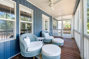 A covered porch with wicker furniture and a ceiling fan. - Family & Dog Friendly Retreat w. Beach, Dog, and Baby Gear. Screened porch! (Oak Island)