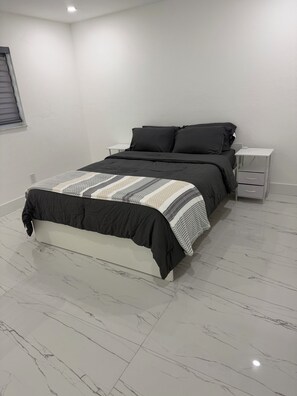 Ein Schlafzimmer mit einem Bett, einem Nachttisch und einer Kommode.