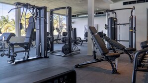 A gym with various exercise machines, benches, and weight racks. - Oceanfront Villa | Balcony | Designer 3BR with Endless Views (Long Bay Hills)