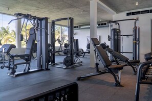 A gym with various exercise machines, benches, and weight racks. - Oceanfront Villa | Balcony | Designer 3BR with Endless Views (Long Bay Hills)