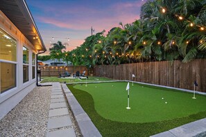 Ein Garten mit Kunstgrasanlage, Putting-Green und Holzzaun.
