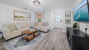 A living room with a sofa, coffee table, and a television. - Coastal Retreat w/ Putting Green & Private Backyard. Minutes to Beach & Downtown (Venice)