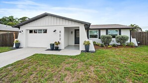 A single-story house with a garage, a front door, and a small porch. - Coastal Retreat w/ Putting Green & Private Backyard. Minutes to Beach & Downtown (Venice)