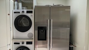 A compact kitchen with a built-in washer and dryer, a stainless steel refrigerator, and a skylight above. - Fullhouse - Croydon centre (Croydon)