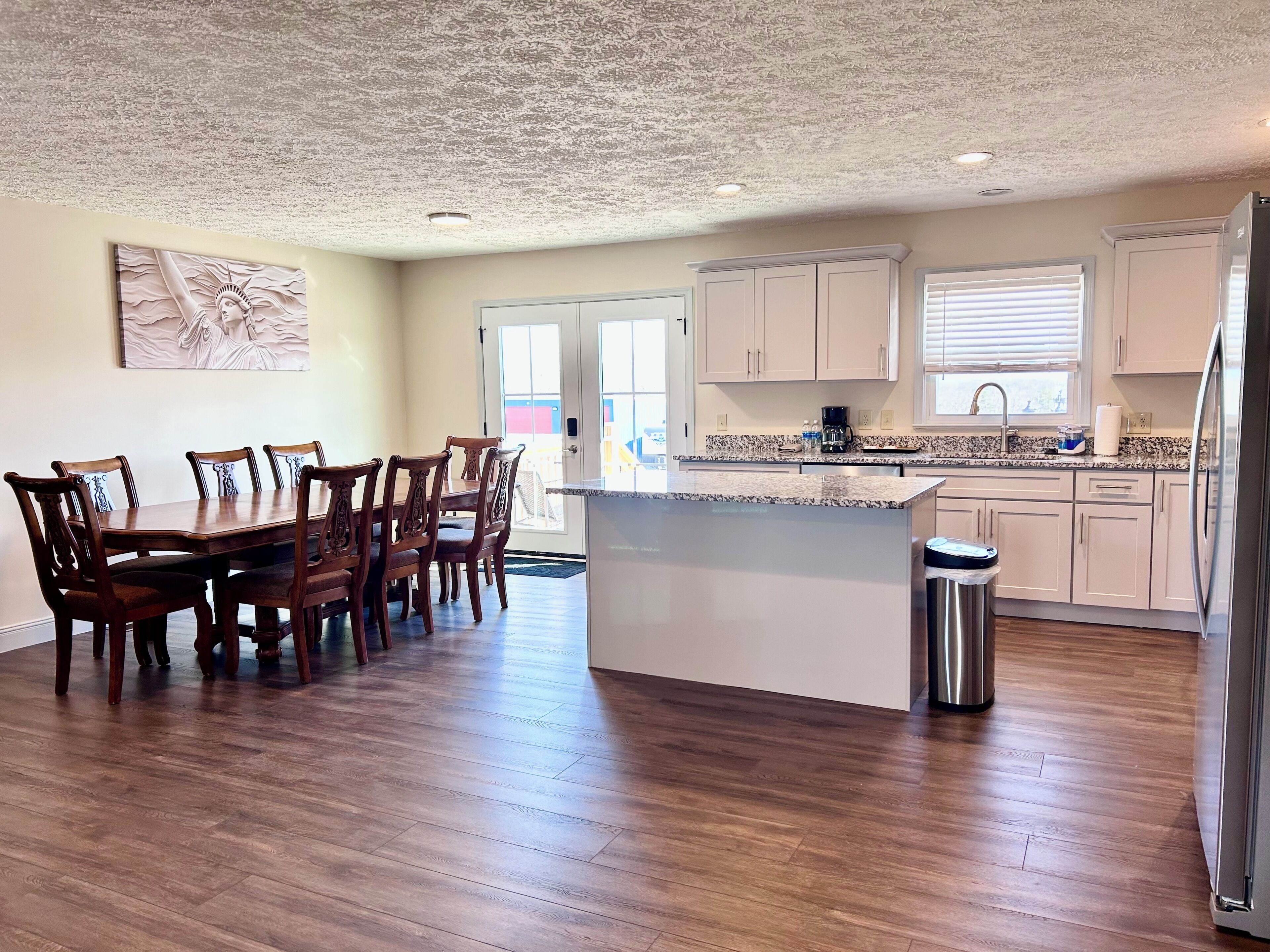 Una cocina amplia con una isla central, una mesa de comedor de madera y sillas.