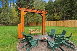 Eine Holzpergola mit Feuerstelle und Sitzbereich.