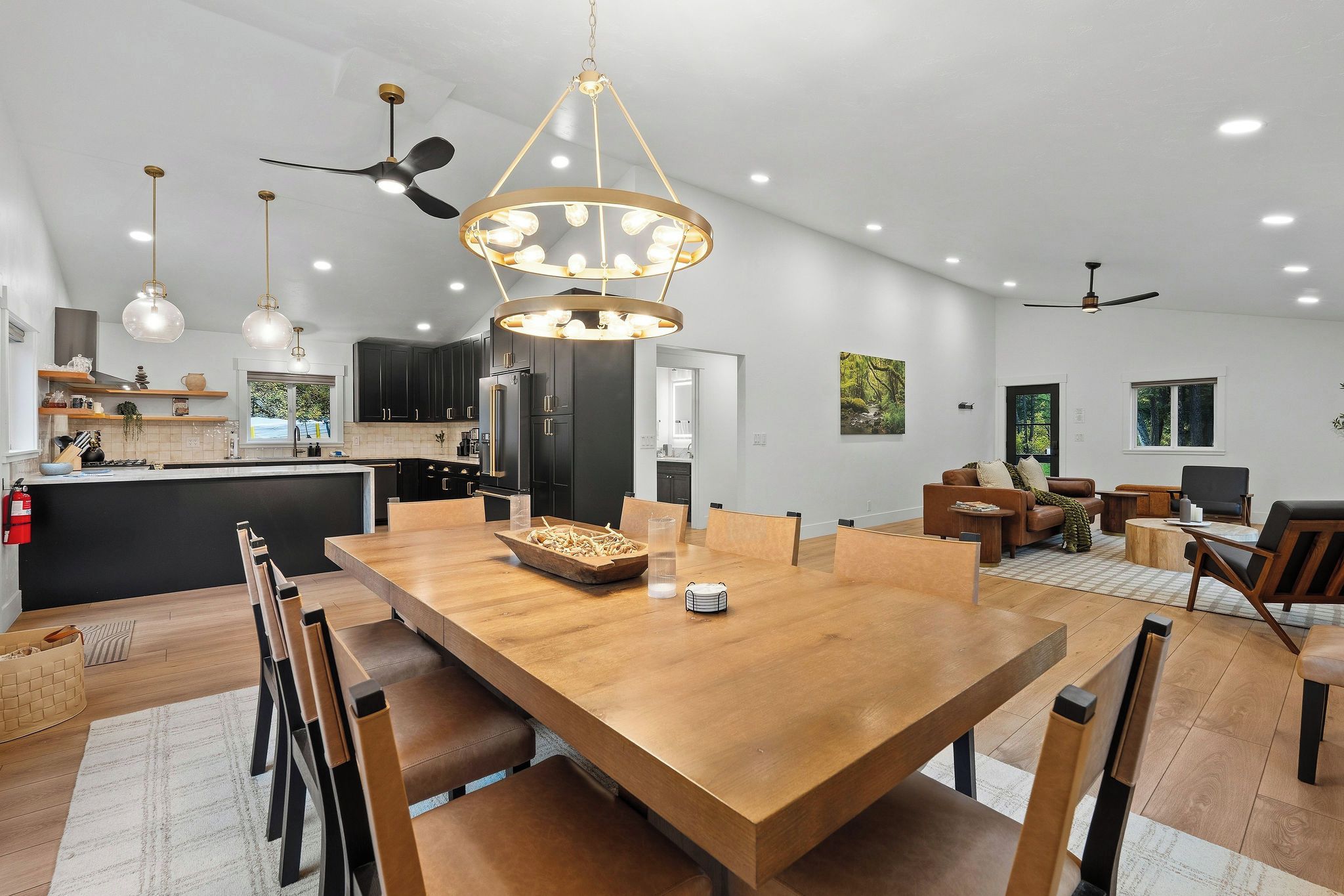 A modern kitchen with dark cabinets, a central island, and pendant lighting.