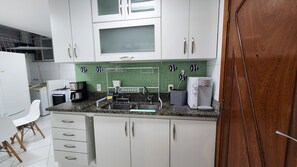 A kitchen with white cabinets, a microwave, a coffee maker, and a sink. - 3 Bedrooms in Copacabana - Near Arpoador (Rio de Janeiro)