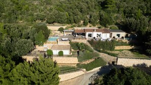 Una villa con piscina, mobiliario de exterior y un sendero de piedra.
