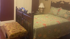Une chambre à coucher avec un lit, une table de chevet, une lampe et un banc.