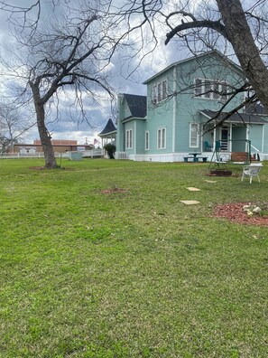 A large, light blue house with a porch and a swing set. - Spacious Historical 4-bedroom house in tranquil Hemphill with AC (Hemphill)