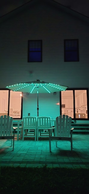 Eine Außenpatio-Terrasse mit Tisch und Stühlen unter einem Baldachin mit Lichterketten.