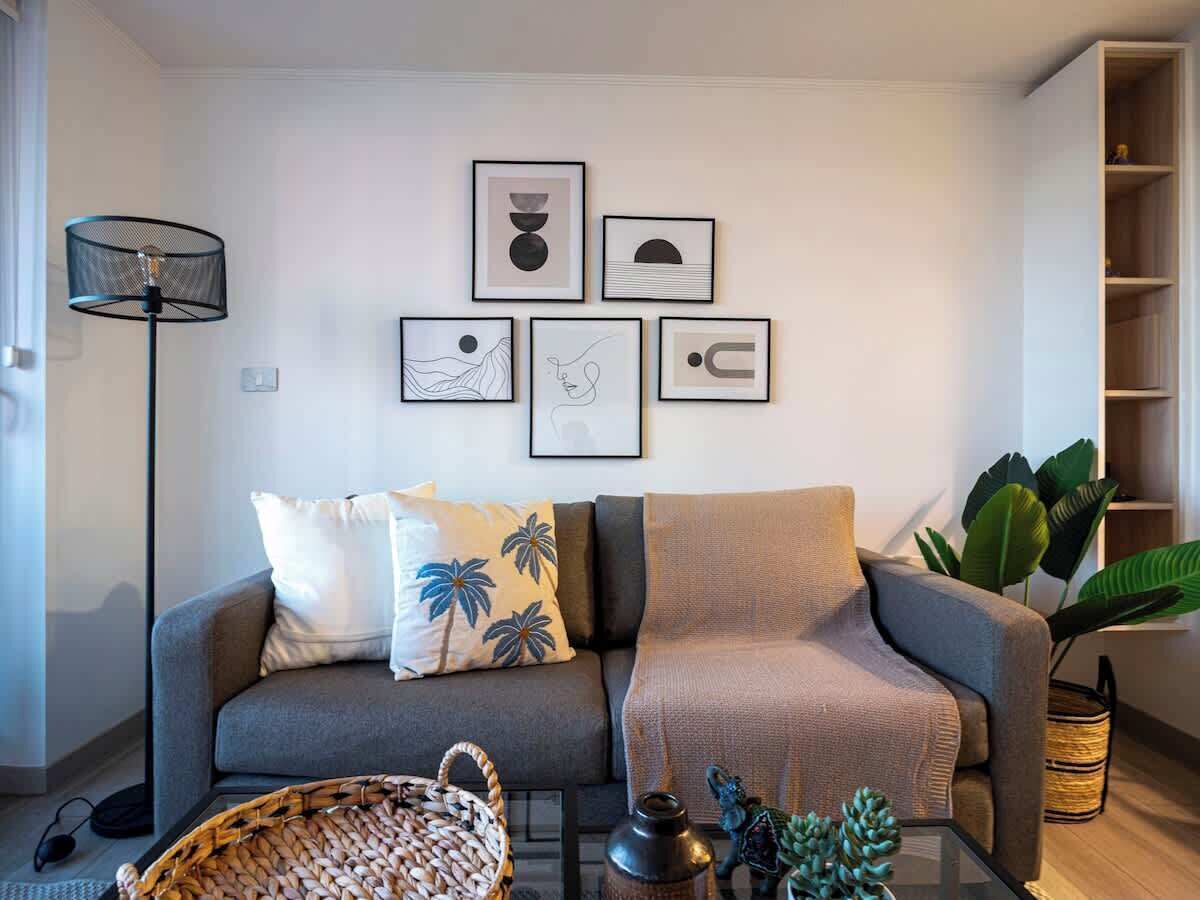 Un salon moderne avec un canapé gris, une table basse et un lampadaire.