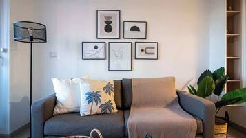 A modern living room with a grey sofa, a coffee table, and a floor lamp.