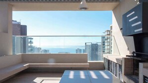 En moderne balkon med havudsigt, et siddeområde og en indbygget grill.