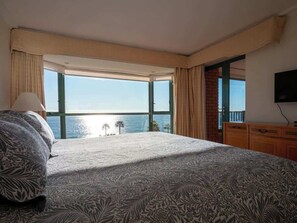 A hotel room with a large bed, a TV, and a view of the sea. - Oceanfront Luxury Apt w/ 8 PAX , Pool & Gym (Viña del Mar)