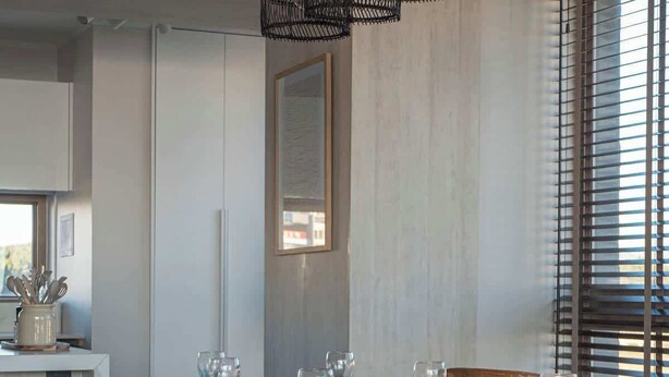 A dining area with a wooden table set for six, surrounded by wooden chairs. - Costa Home 7 PAX - Lujoso - WIFI 1000 MBPS HS (Concón)