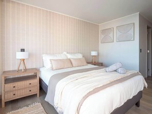 A bedroom with a bed, nightstands, and wall art. - Costa Home 7 PAX - Lujoso - WIFI 1000 MBPS HS (Concón)