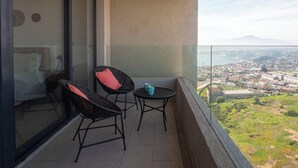 Ein Balkon mit zwei Stühlen und einem Tisch mit Blick auf die Stadt.