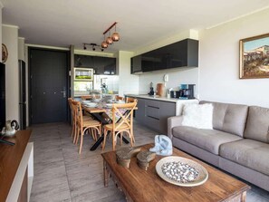 Eine moderne Küche mit Essbereich, einer Couch und einem Couchtisch.