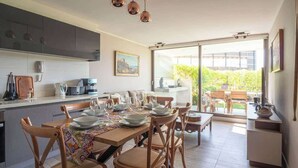 Uma cozinha moderna com área de refeições, janelas amplas e vista para o exterior.
