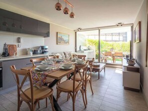 Eine moderne Küche mit Essbereich, großen Fenstern und Blick ins Freie.