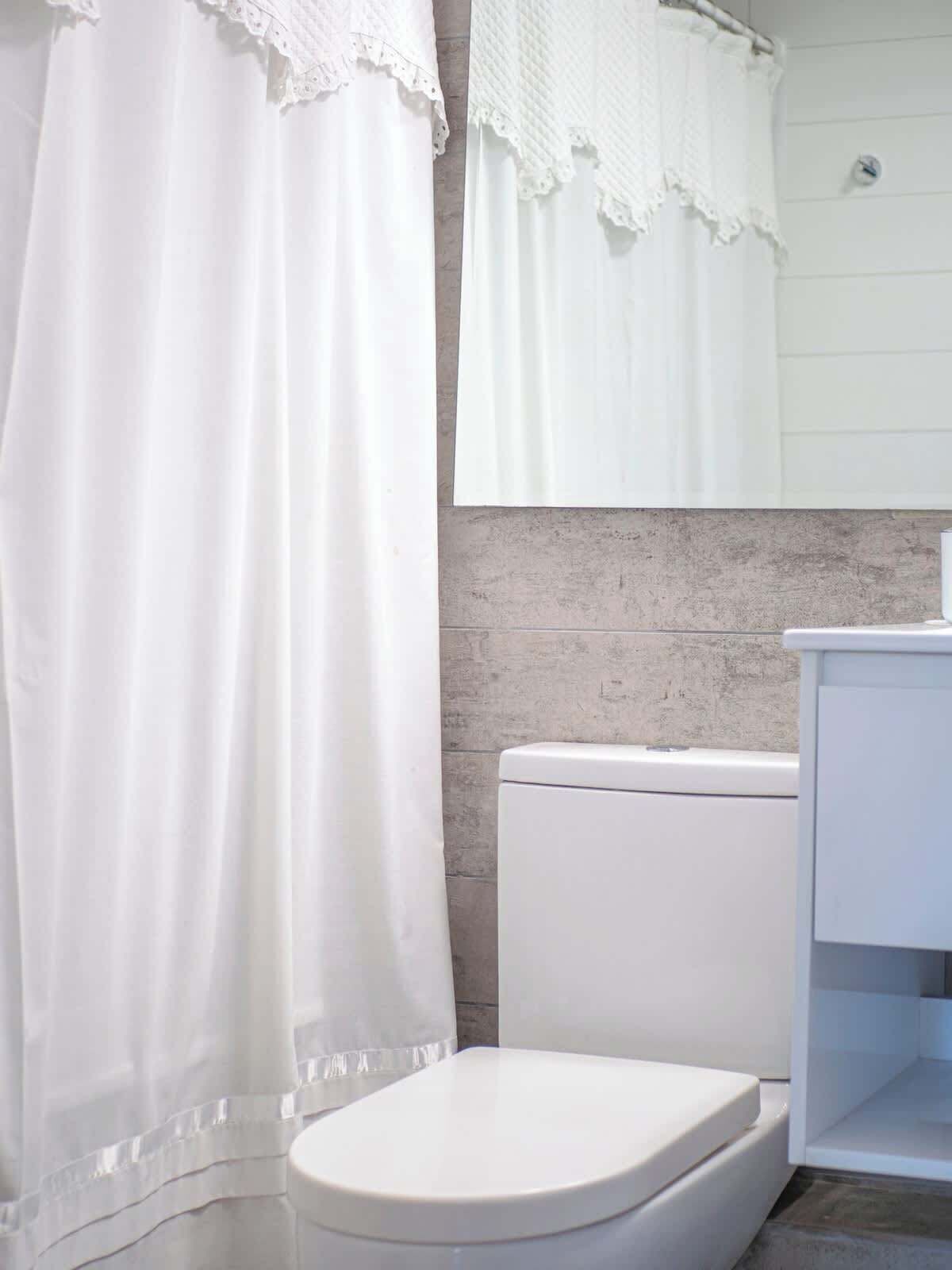 Une salle de bain avec des toilettes, un lavabo et un miroir.