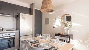 Uma cozinha moderna com área de refeições, equipada com fogão, forno e geladeira.