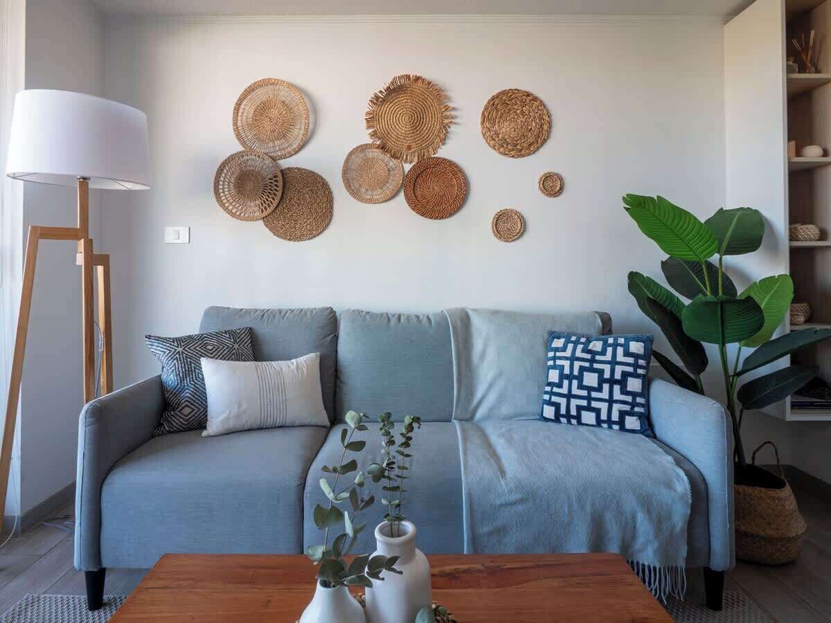 Una sala de estar con un sofá, una mesa de centro, una lámpara y una planta grande.