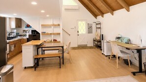 Une cuisine spacieuse avec des poutres en bois, un coin repas et un espace de travail équipé d’un ordinateur.
