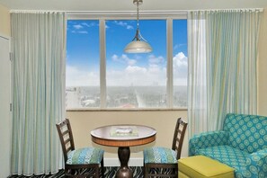 A room with a round table, two chairs, a sofa, and a view of a cityscape through a large window. - Cozy 1-bedroom apartment with AC in fantastic Hollywood (Hollywood)
