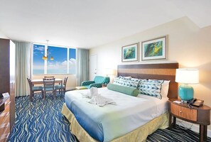 A hotel room with a large bed, a desk, a chair, and a view of the sky. - Cozy 1-bedroom apartment with AC in fantastic Hollywood (Hollywood)