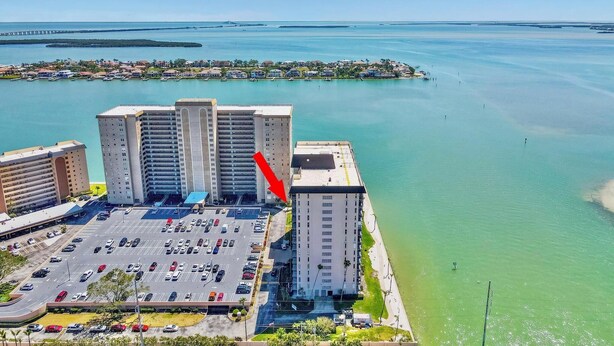 A high-rise hotel with a parking lot, adjacent to a body of water. - Coastal Condo w/ Panoramic Water Views (St. Petersburg)