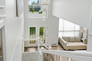 A multi-level interior with a staircase, a sofa, and a view of the outside. - 4BR Family Retreat in Surrey (Surrey)