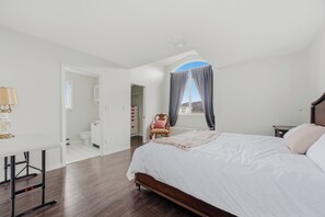 A bedroom with a bed, a desk, a chair, and a window with curtains. - 4BR Family Retreat in Surrey (Surrey)