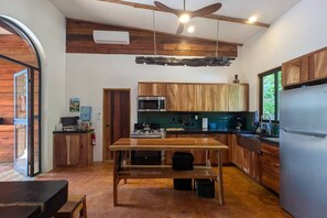 Une cuisine moderne avec des meubles en bois, un îlot central et une cuisinière intégrée.