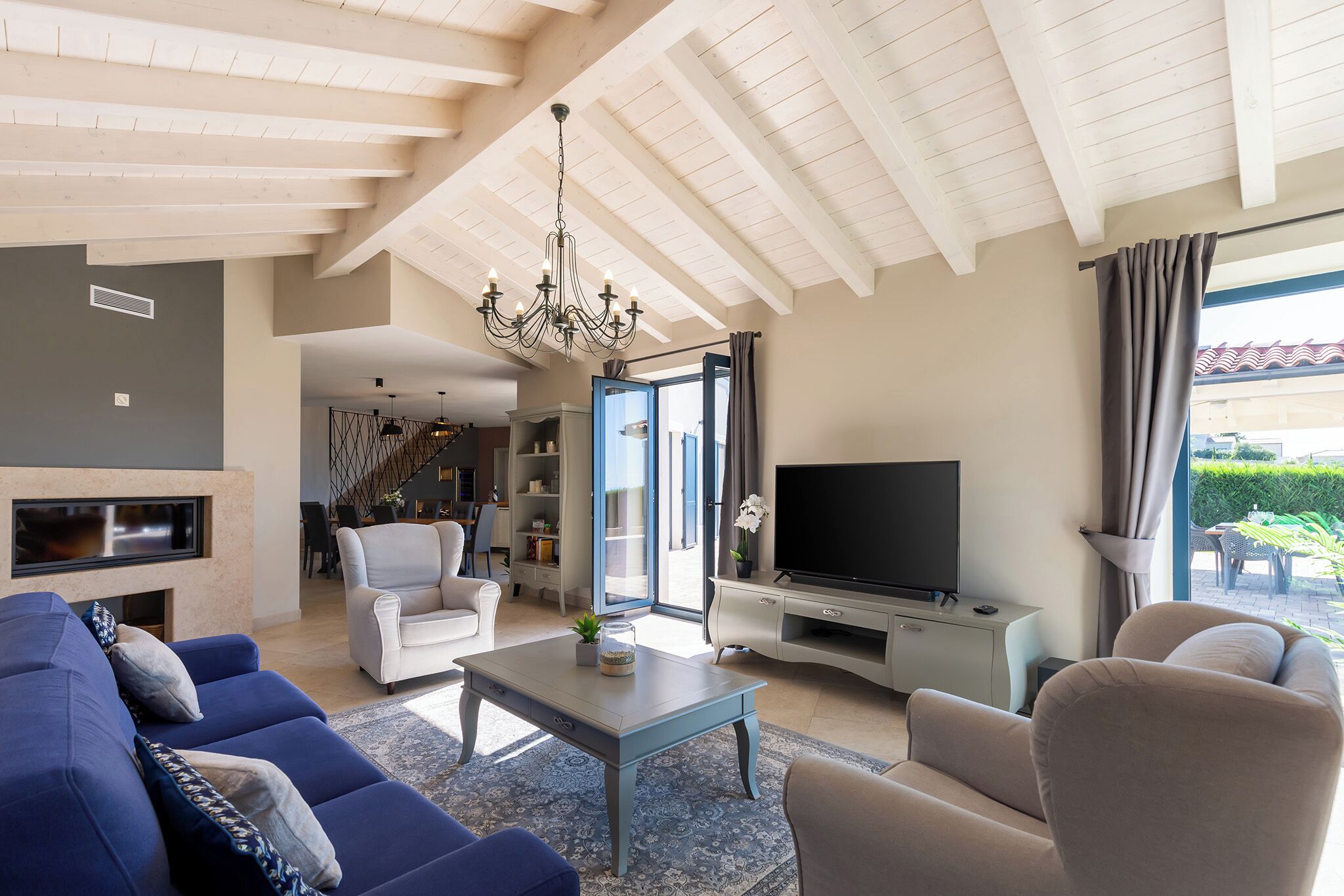 A spacious living room with a fireplace, a television, and a large window.