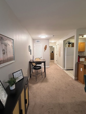 A hallway with a dining area, kitchen, and a door leading to another room. - Cozy 1-bedroom condo in peaceful Biloxi with AC and gym access for 2 adults only (Biloxi)