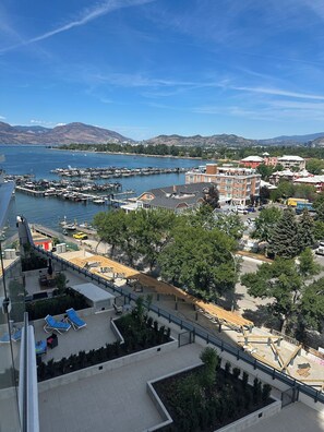 A coastal marina with boats docked, a clear sky, and a view of distant mountains. -     KELOWNA LUXURY LAKEVIEW ESCAPE WITH RESORT AMENITIES GALORE (Kelowna)
