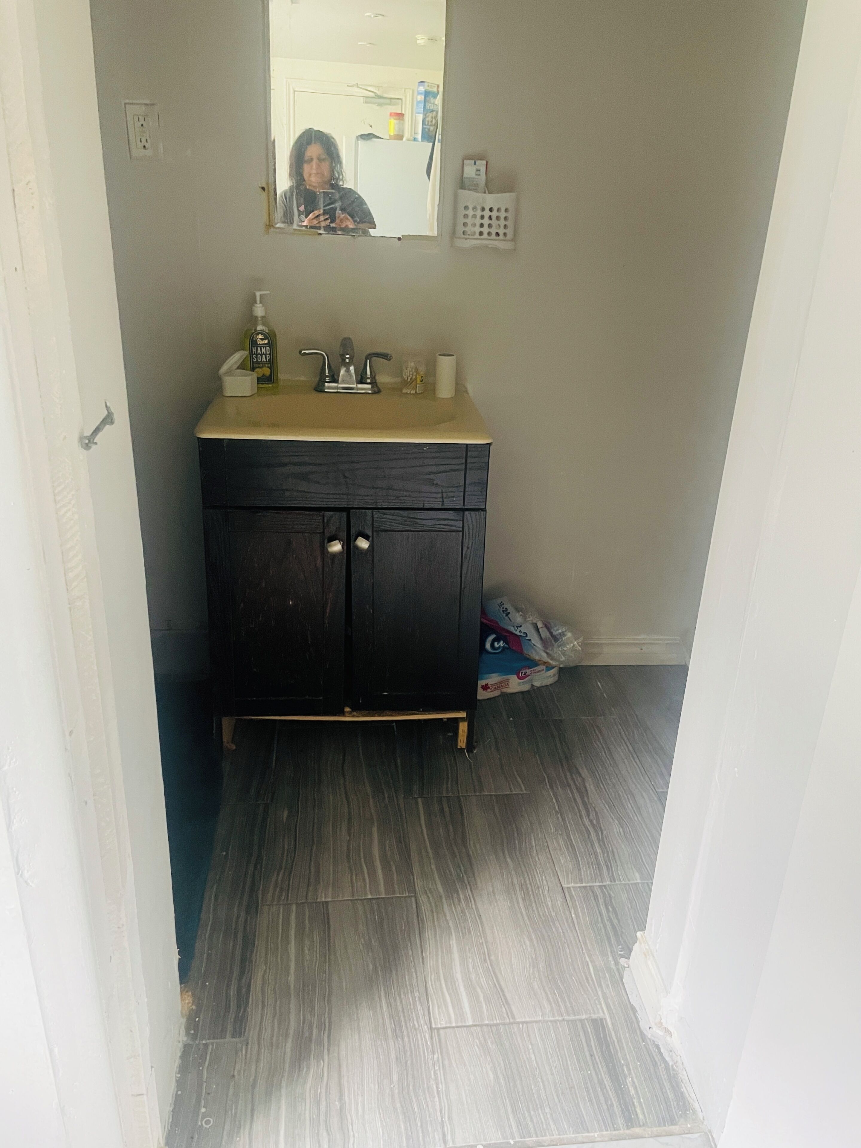 Un baño con tocador de madera oscura, lavamanos y espejo.
