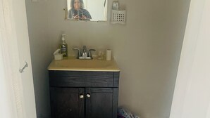 A bathroom with a dark wooden vanity, a sink, and a mirror. - Apartment for rent (Toronto)