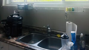 A kitchen with a window, a sink, a coffee maker, and various kitchen items. - Apartment for rent (Toronto)