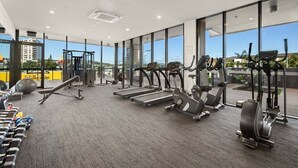 Una palestra con tapis roulant, ellittiche e pesi liberi.