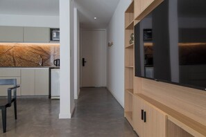 Eine moderne Küche mit Einbauofen, ein Essbereich mit einem Stuhl und ein Flur, der zu einer Tür führt.
