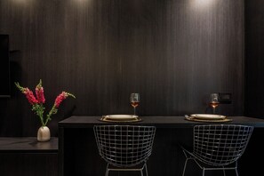 A dark wooden dining table with two chairs, each with a metal wireframe design. - Modern Recoleta Studio | Coworking and Shared BBQ (Buenos Aires)